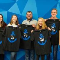 Seven students showing their I am GV shirts